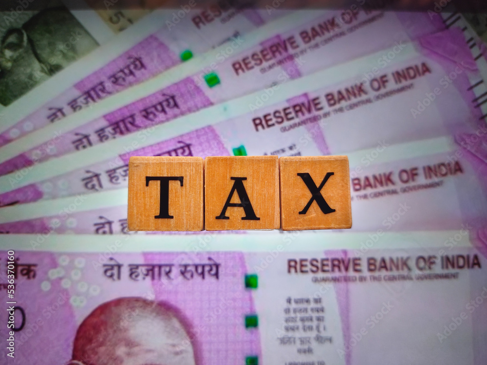 Fototapeta premium TAX by letters on wooden beads or block with 2000 rupee notes background.