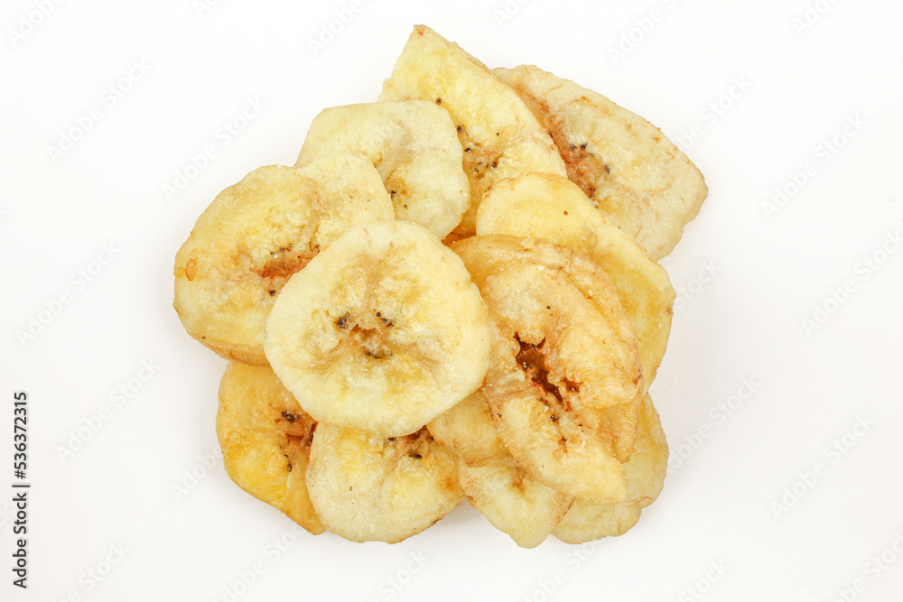 Pile of dried and sliced healthy banana snack isolated on white background