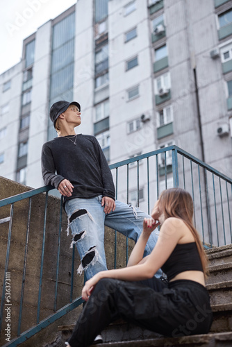 Teenagers are posing on the stairs in the urban exterior.