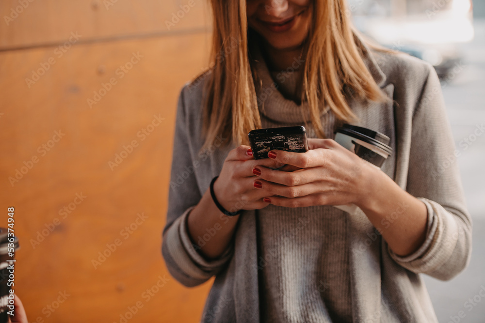 macro photo of a girl drinking coffee and using a cell phone during a break from work. macro photo of a girl drinking coffee and using a cell phone during a break from work.