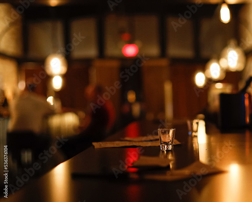 Shot glass on counter in a dark moody bar