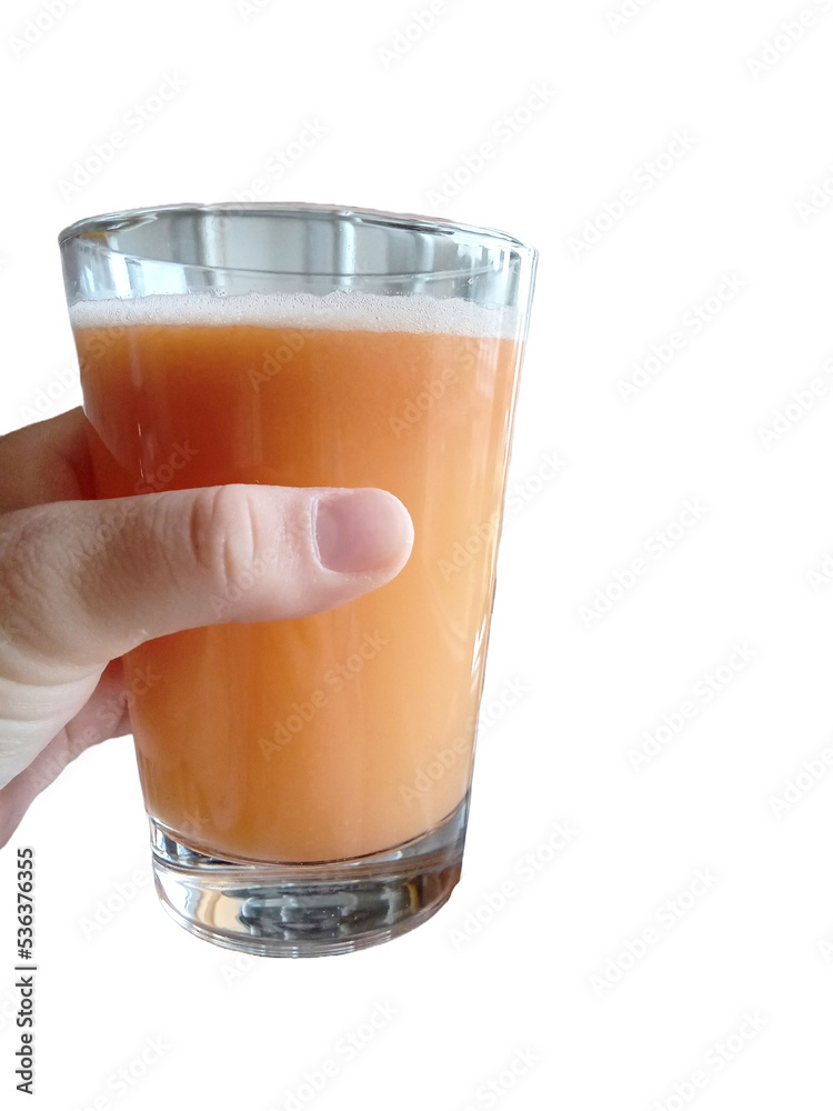 a person holds a glass of fresh carrot, apple and pear juice a person holds a glass of fresh carrot, apple and pear juice