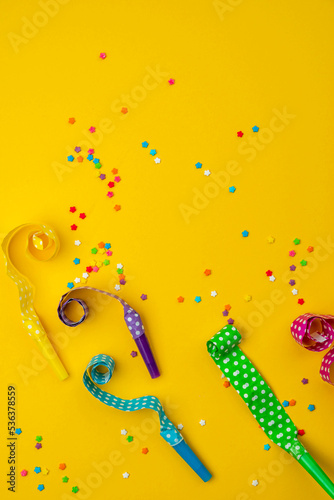 Abstract colored party background. Multi-colored party horns, serpentine ribbons, colored sprinkles scattered on bright paper. Base for design nice backdrop, wallpaper, poster photo