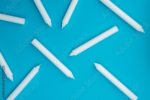 New white wax candles on a blue background