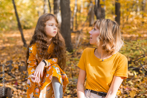 Mother soothes her unhappy sad daughter in autumn nature. Children depression concept