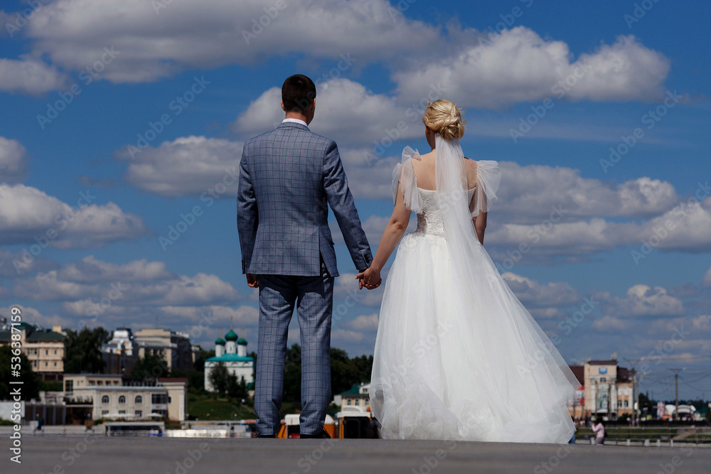 the bride and groom standing on the red square of Cheboksary