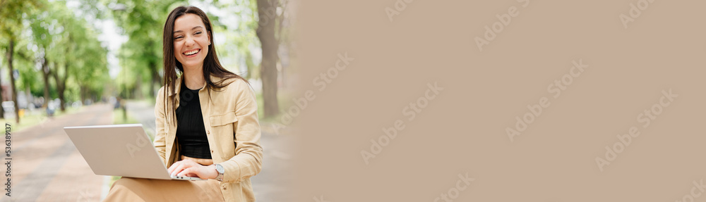 Banner of a successful girl with a laptop working on the street Banner of a successful girl with a laptop working on the street