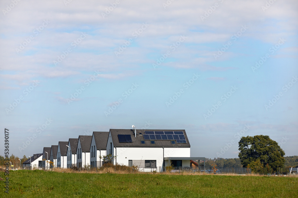 Nowe osiedle mieszkaniowe z panelami słonecznymi na jednym dachu - obrazy, fototapety, plakaty 