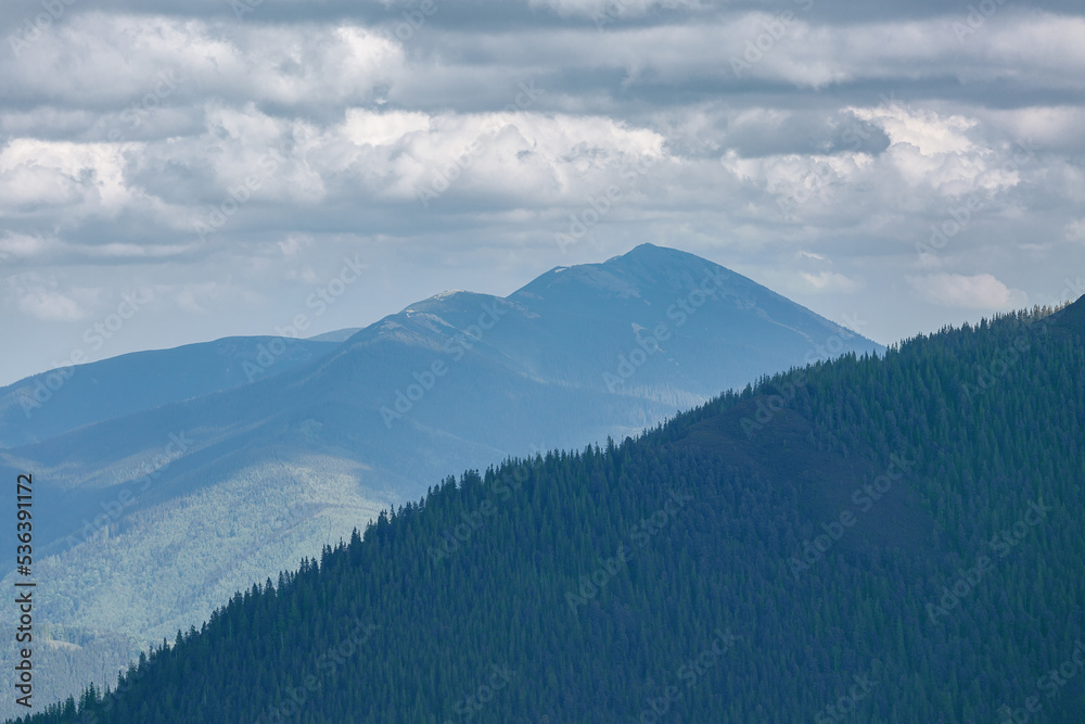 Summer mountain landscape in the afternoon under a cloudy sky. Stones and mountain pines in the foreground. Active lifestyle and hiking in the mountains. Summer mountain landscape in the afternoon under a cloudy sky. Stones and mountain pines in the foreground. Active lifestyle and hiking in the mountains.