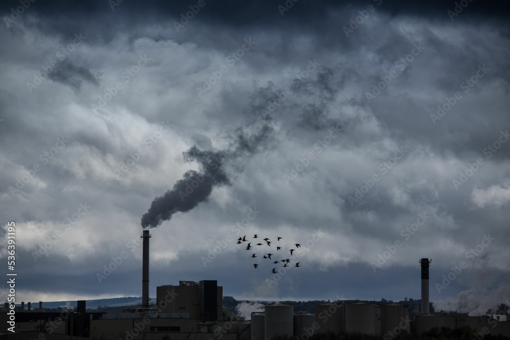 Industrial buildings, factory emitting smoke and pollution going into the  air as dark clouds Stock-Foto | Adobe Stock