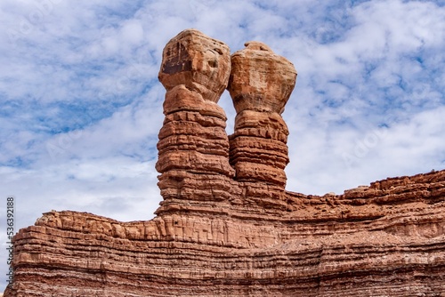 Navajo Twins sandstone formations on blue cloudy sky background in Bluff, Utah photo