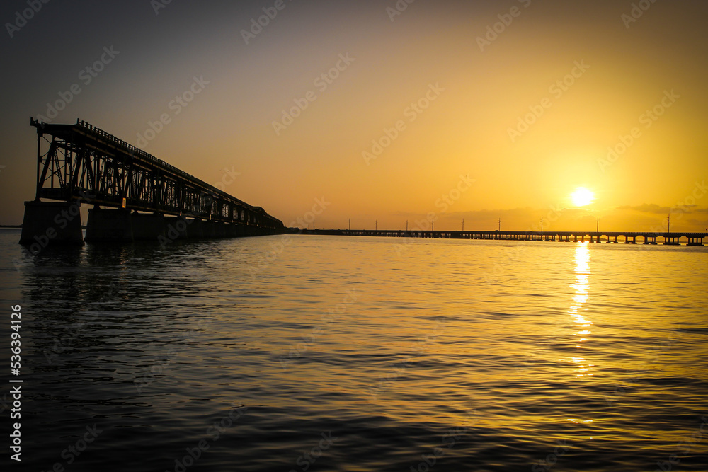 Sunset from Bahia Honda State Park in Florida showing old bridge and reflection of sunset in the water.