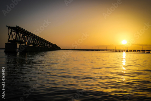 Sunset from Bahia Honda State Park in Florida showing old bridge and reflection of sunset in the water.