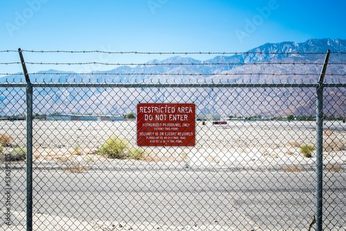 Fence with a red restricted area sign photo