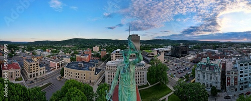Panoramic aerial shot of the cityscape of downtown Binghamton, with a green statue in the middle