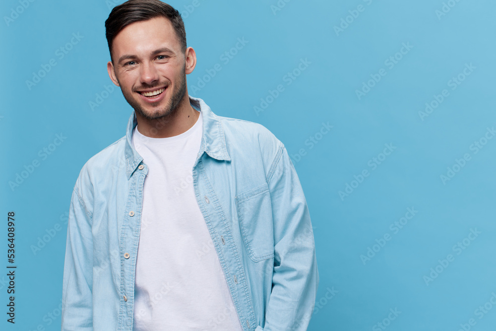 Close up portrait of happy tanned handsome man in casual basic t-shirt smile at camera posing isolated on blue studio background. Copy space Banner Mockup. People emotions Lifestyle concept Close up portrait of happy tanned handsome man in casual basic t-shirt smile at camera posing isolated on blue studio background. Copy space Banner Mockup. People emotions Lifestyle concept