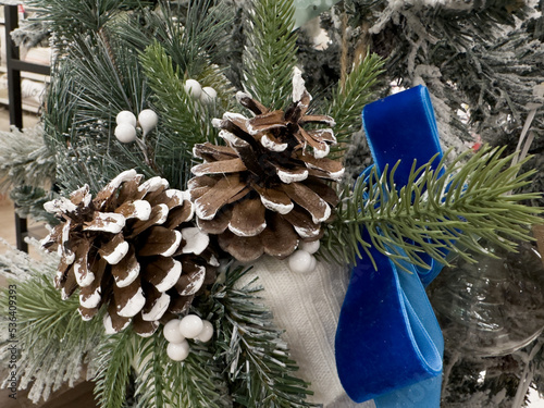 Pine cones on a wintery branch with a blue bow. Abstract composition for Christmas projects and backgrounds