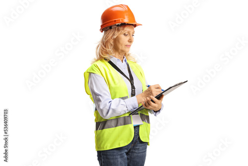 Female engineer with a safety vest and helmet writing a document