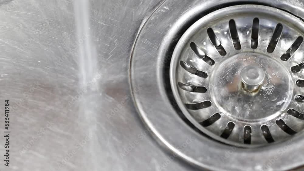 Water running down the sink drain. Water running down the sink drain.