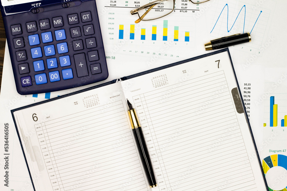 Top view office table desk. Financial report. Flat lay. Workspace with Business office supplies, numbers and empty sheet of diary, diagrams, pen, glasses, calculator. Copy space for text. Top view Top view office table desk. Financial report. Flat lay. Workspace with Business office supplies, numbers and empty sheet of diary, diagrams, pen, glasses, calculator. Copy space for text. Top view