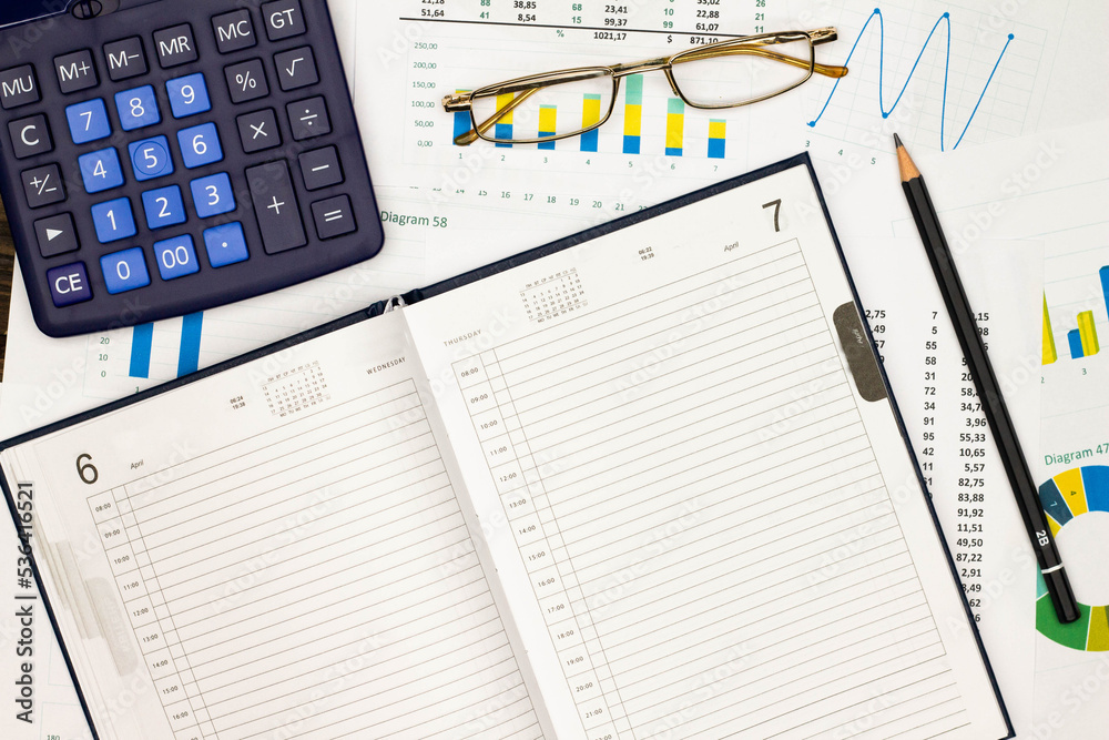 Top view office table desk. Financial report. Flat lay. Workspace with Business office supplies, numbers and empty sheet of diary, diagrams, pencil, glasses, calculator. Copy space for text. Top view Top view office table desk. Financial report. Flat lay. Workspace with Business office supplies, numbers and empty sheet of diary, diagrams, pencil, glasses, calculator. Copy space for text. Top view