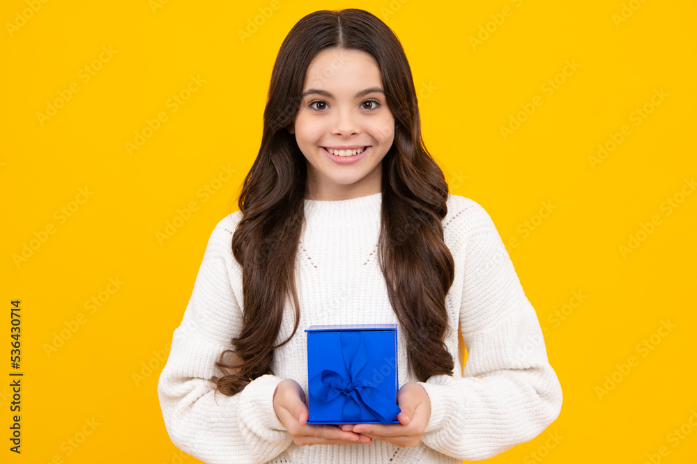 Child with gift present box on isolated studio background. Gifting for kids birthday. Excited teenager girl. Child with gift present box on isolated studio background. Gifting for kids birthday. Excited teenager girl.