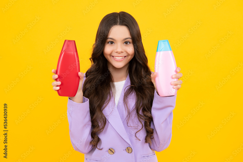 Child with shampoo conditioner. Daily cosmetic care. Teenager hold bottle of hair and skin care. Beauty health and cosmetics. Happy teenager, positive and smiling emotions of teen girl. Child with shampoo conditioner. Daily cosmetic care. Teenager hold bottle of hair and skin care. Beauty health and cosmetics. Happy teenager, positive and smiling emotions of teen girl.