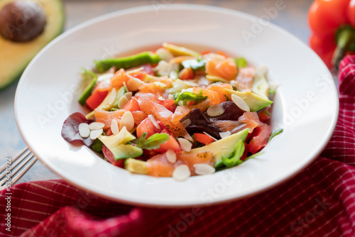 vegetable salad with hand salmon and avocado in a restaurant