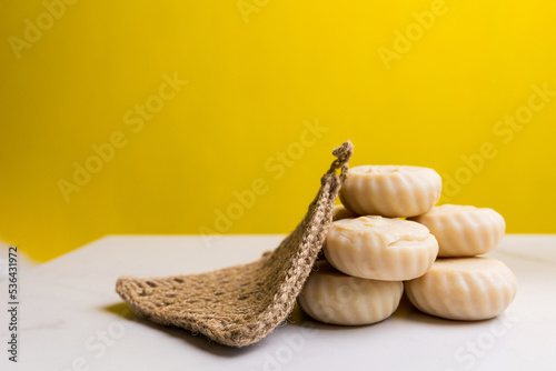 Handmade soap and washcloth on a yellow background. Free space for text or advertising.