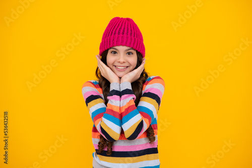 School girl in winter clothes and warm hat. Winter holiday vacation. Child fashion model. Happy teenager, positive and smiling emotions of teen girl.