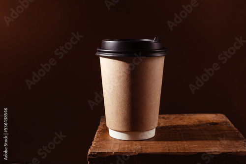 A paper drink cup with you on a brown background with a place for text. Stylish concept of hot coffee to take away. Hot Americano on a wooden countertop