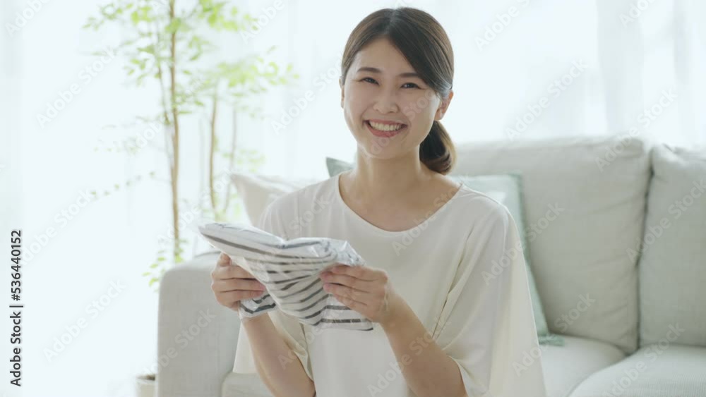 通販で購入した服を持つ女性(ネットショッピング・フリマアプリ) 通販で購入した服を持つ女性(ネットショッピング・フリマアプリ)