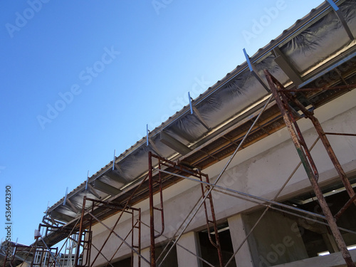 MELAKA, MALAYSIA - SEPTEMBER 16, 2022: Installation of the aluminum cladding frame at the end of the roof is underway. The metal decking roof system is equipped with a heat-resistant silsalation layer