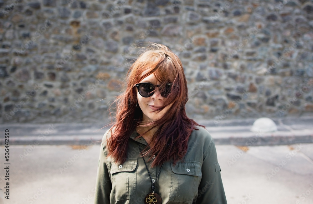 happy smiling young brunette woman in sunglasses walking along the city street happy smiling young brunette woman in sunglasses walking along the city street