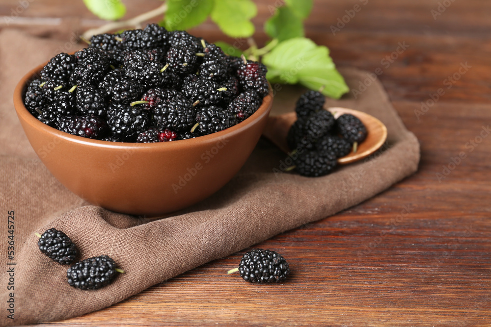 Delicious ripe black mulberries on wooden table, space for text Delicious ripe black mulberries on wooden table, space for text