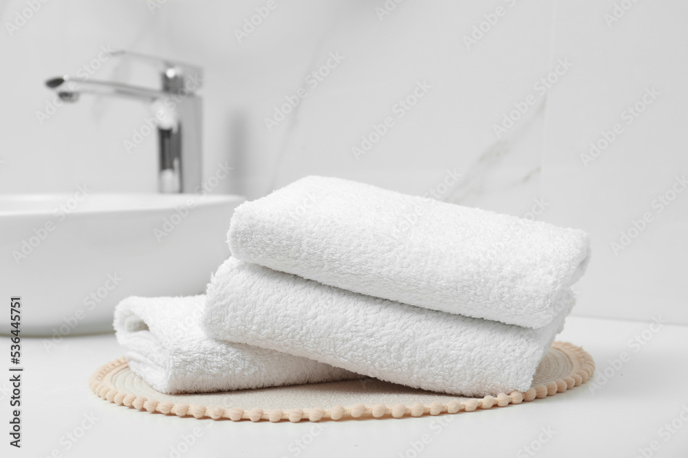 Folded bath towels on white table in bathroom Folded bath towels on white table in bathroom