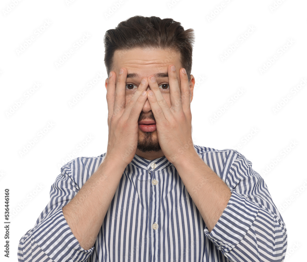 Embarrassed man covering face with hands on white background
