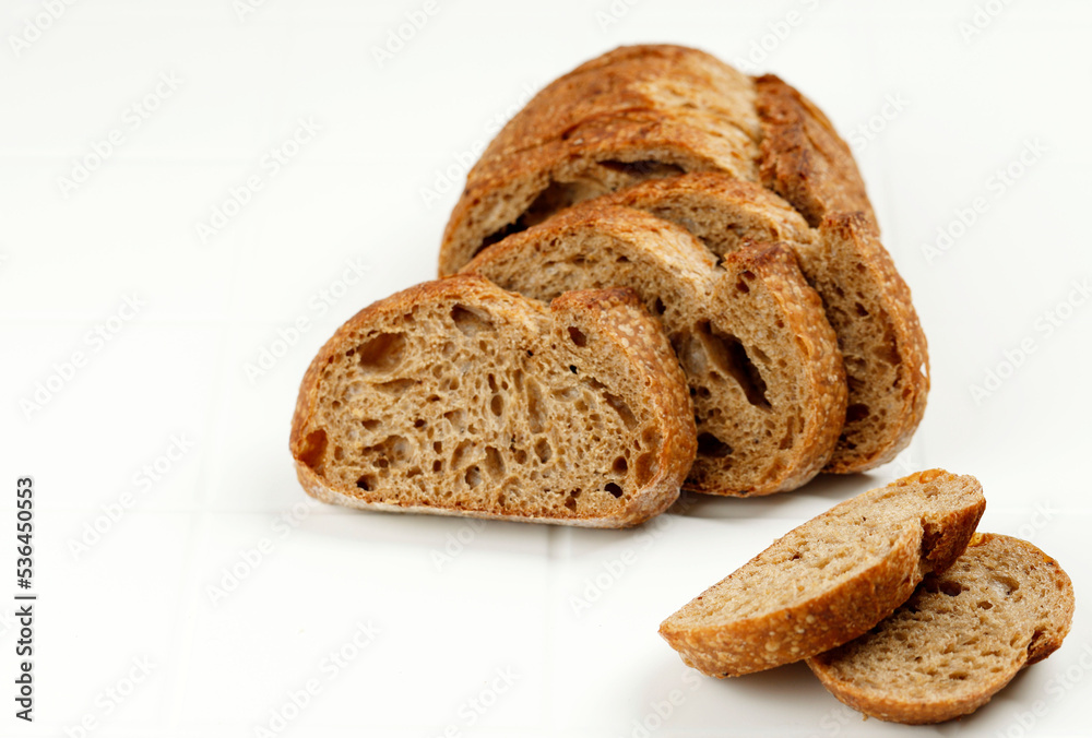 Loaf of Rye Bread Cut into Slices on White Background