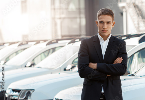 Young male consultant in auto show standing near cars and looking at camera © Friends Stock