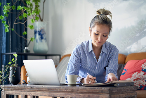 Photography mature asian woman working from home using notebook computer