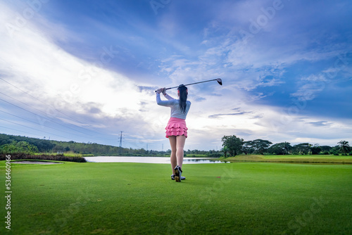 Professional woman golfer teeing golf in golf tournament competition at golf course for winner.	