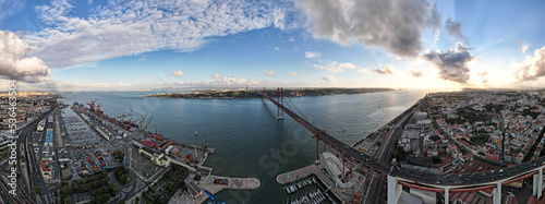 Billede på lærred Aerial panoramic view of 25 de Abril bridge over the Tagus River at sunset in Lisbon, Portugal