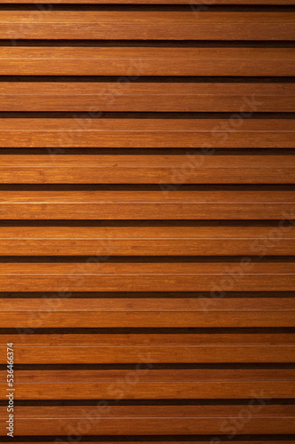 Orange and Tan Teak Hardwood Planking with Black Spacing In Between.