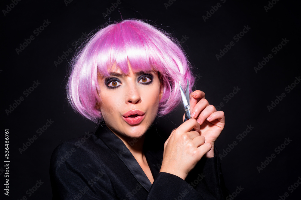 Fototapeta premium Woman with scissors having hair cut. Beautiful girl with straight hair with professional scissor on black. Haircare concept.