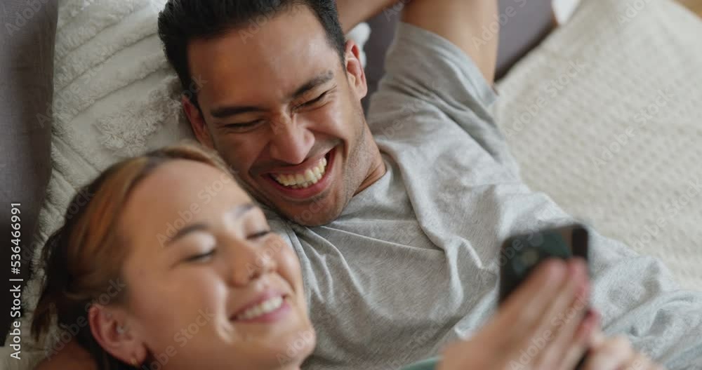 Asian couple, phone and bonding while laughing at internet news, social media meme and funny communication in home or house bedroom. Smile, happy and comic man and woman with mobile technology on bed Asian couple, phone and bonding while laughing at internet news, social media meme and funny communication in home or house bedroom. Smile, happy and comic man and woman with mobile technology on bed