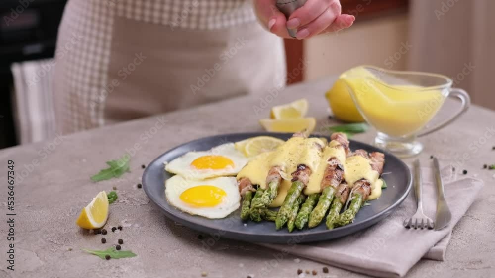 fried eggs and freshly cooked asparagus wrapped with bacon on a plate fried eggs and freshly cooked asparagus wrapped with bacon on a plate