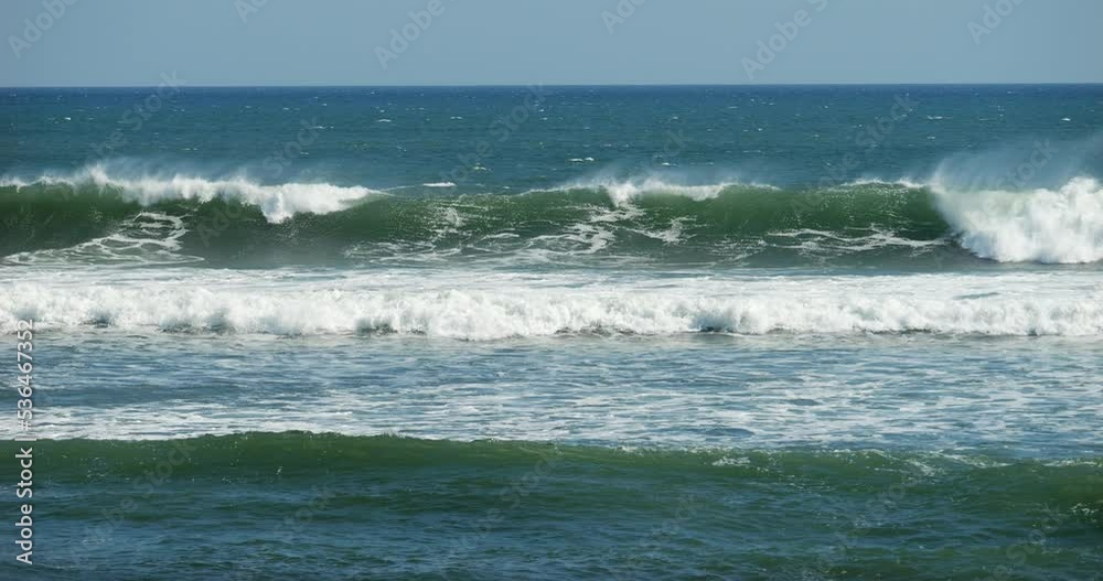 Early breaking waves at surf zone near Bali beach, slow motion shot of water. Beauty and power of nature. Large waves turn to whitewater, water spray driven by wind Early breaking waves at surf zone near Bali beach, slow motion shot of water. Beauty and power of nature. Large waves turn to whitewater, water spray driven by wind