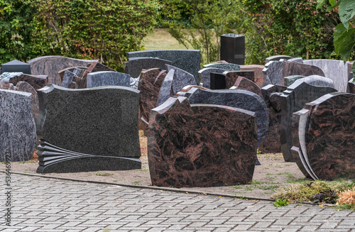 Bei einem Steinmetz stehen viele Grabsteine für die Hinterbliebene zur Auswahl photo