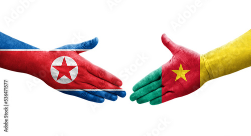 Handshake between Cameroon and North Korea flags painted on hands, isolated transparent image.