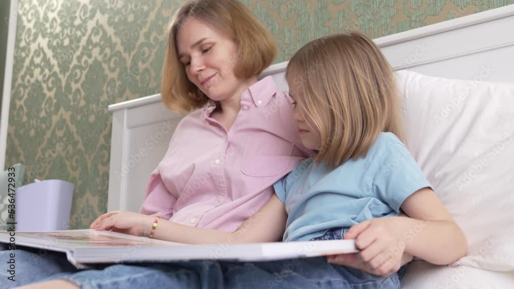 mom and daughter with a photobook with photos of a pregnancy family photo shoot mom and daughter with a photobook with photos of a pregnancy family photo shoot